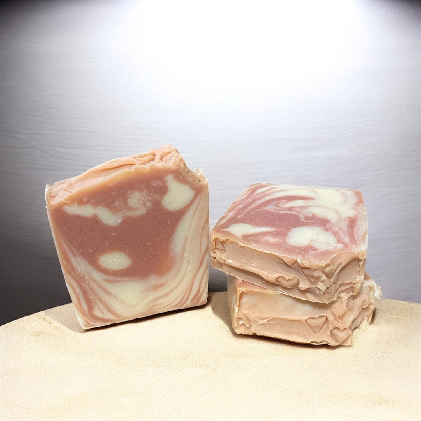 Two bars of marbled soap on a neutral background