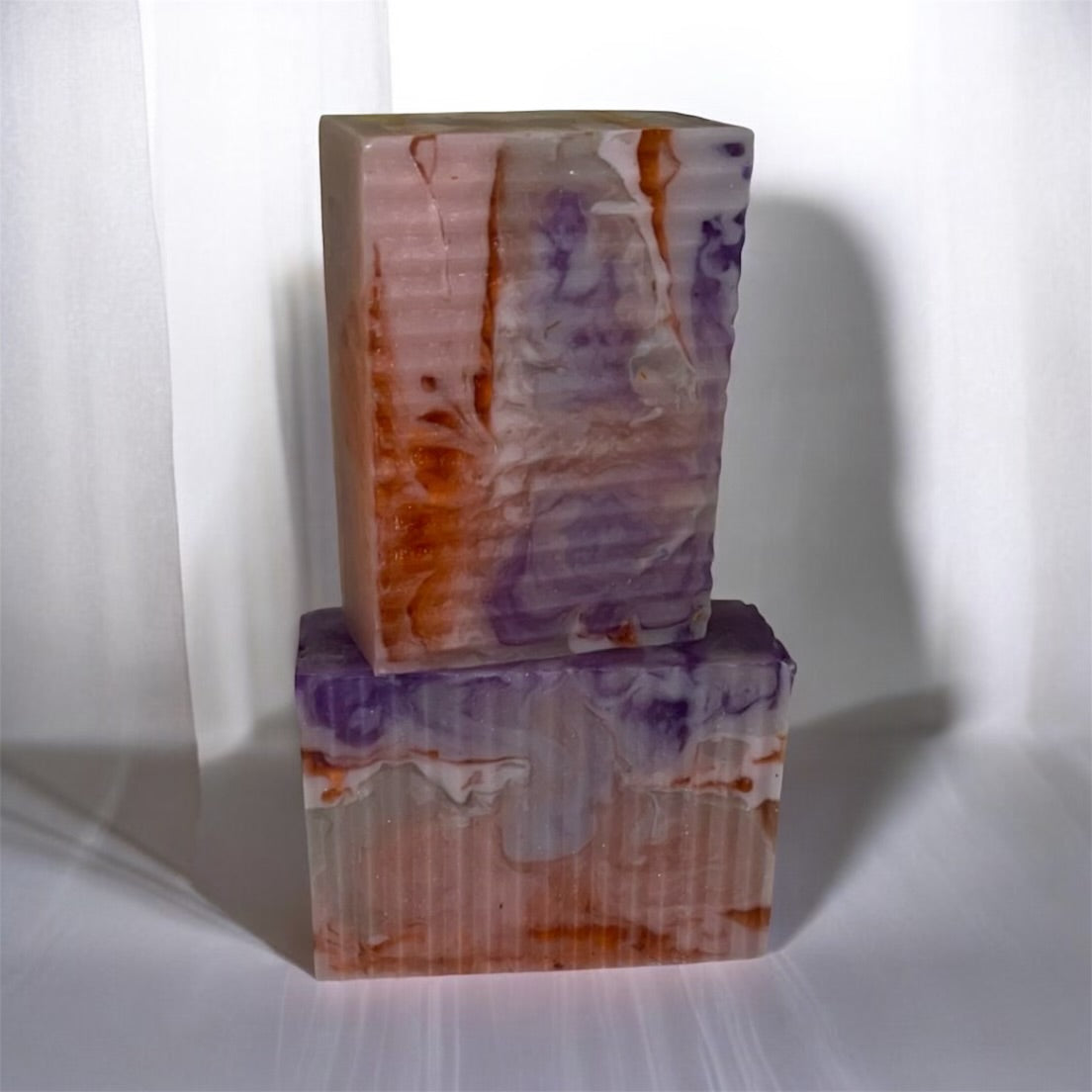 Two marbled soap bars stacked on a white background