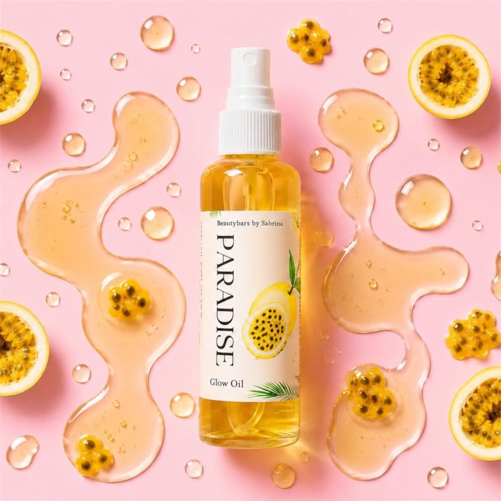 Bottle of Paradise Glow Oil surrounded by passion fruits and oil on a pink background