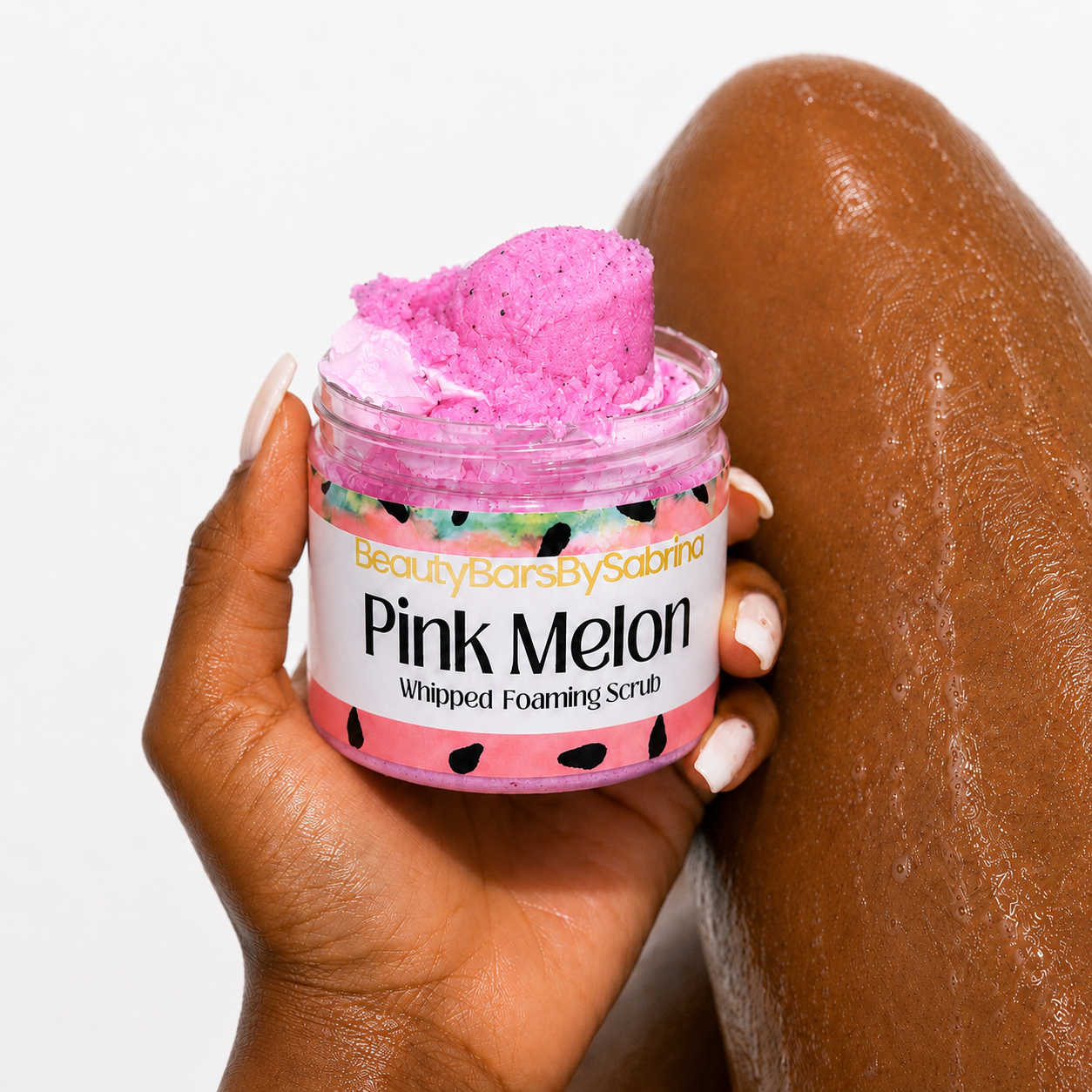 Hand holding pink melon body scrub pink in color with legs and white background 