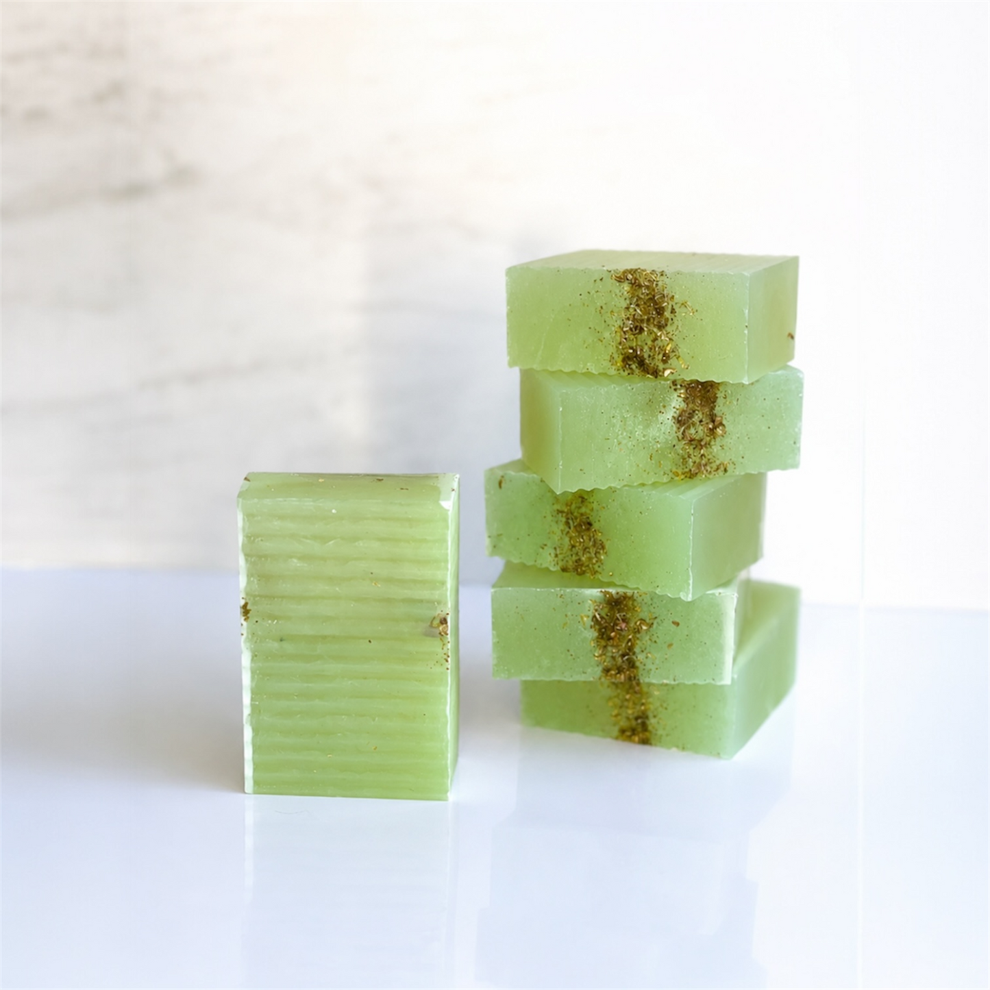 Green soap bars with gold specks on a white background