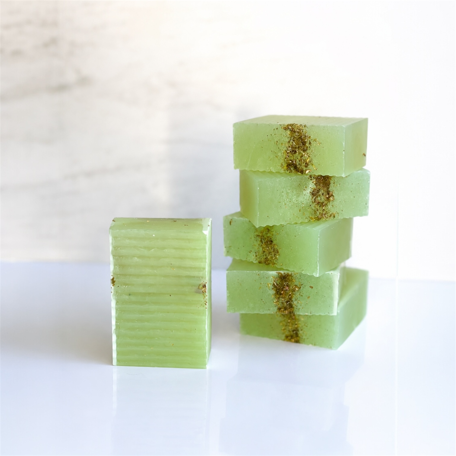 Green soap bars with gold specks on a white background