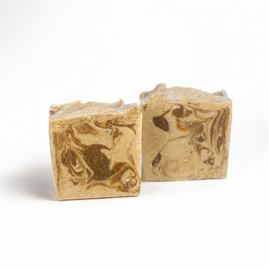 Two marbled gold and brown soap bars on a white background