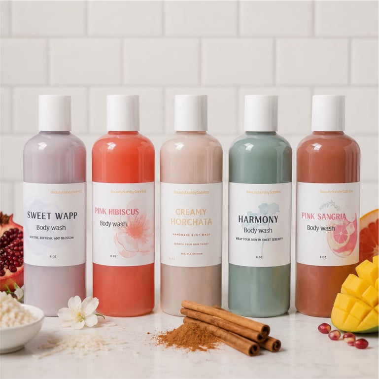 Five bottles of body wash with colorful labels on a white surface with ingredients.