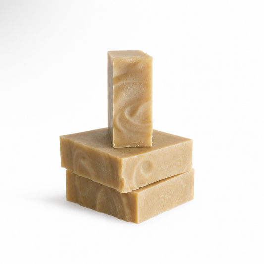 Three bars of brown soap stacked on a white background
