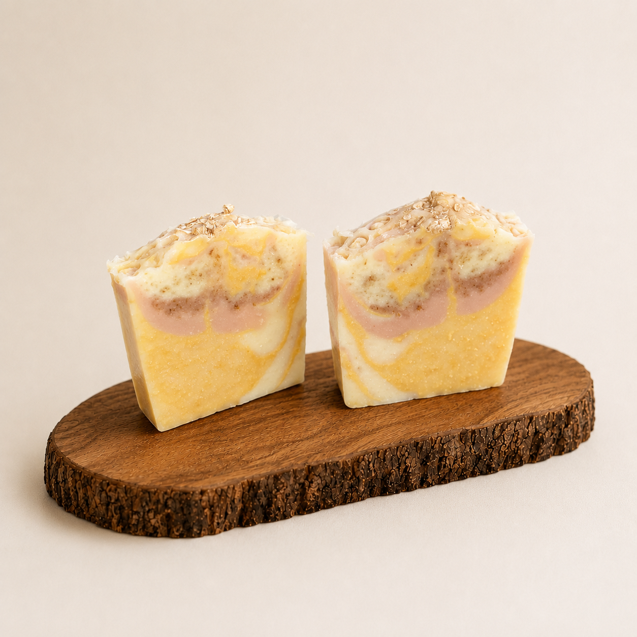 Two marbled soap bars on a wooden stand with a beige background