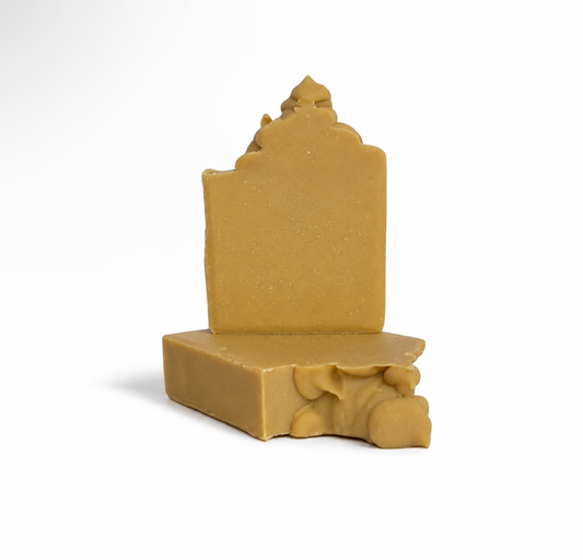 Two pieces of yellow soap with decorative designs on a white background