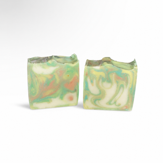Two swirled soap bars with green and orange colors on a white background