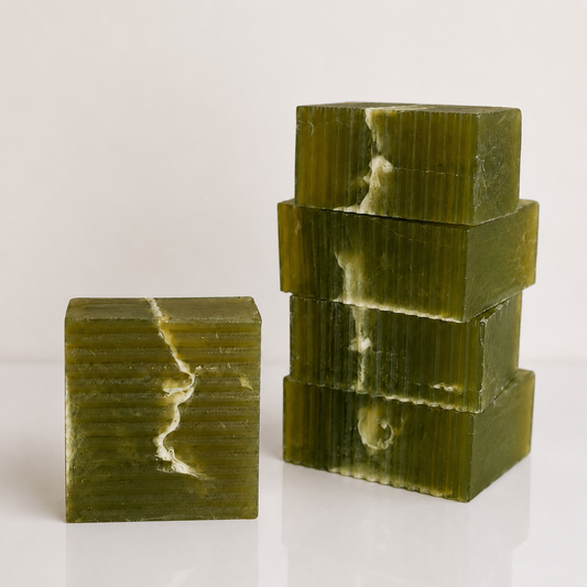 Two stacked rectangular bars of olive green soap with natural white veining, photographed on a clean white background.