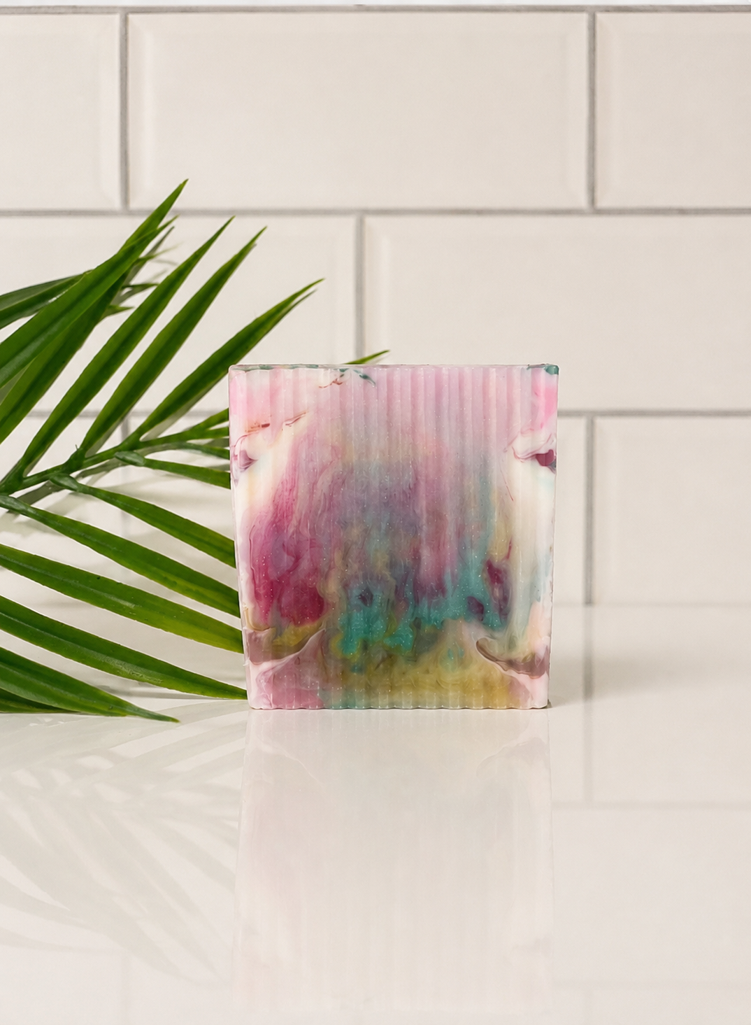 Colorful soap bar with a plant on a white surface
