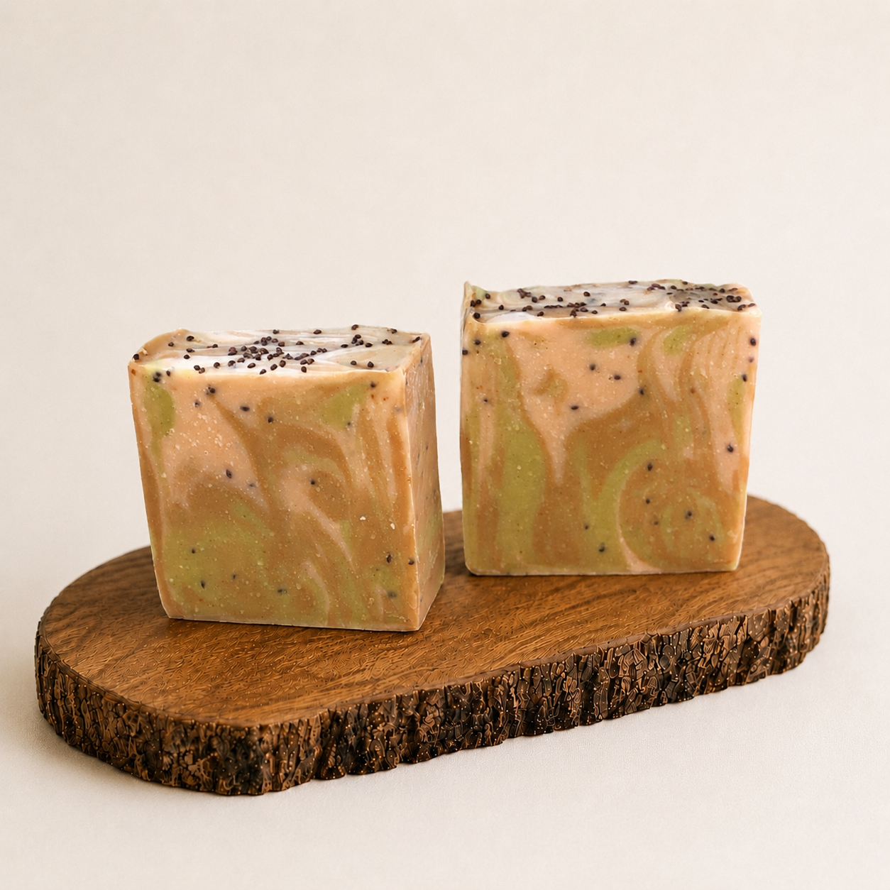 Two square-shaped soaps with a marbled pattern on a wooden stand against a light background