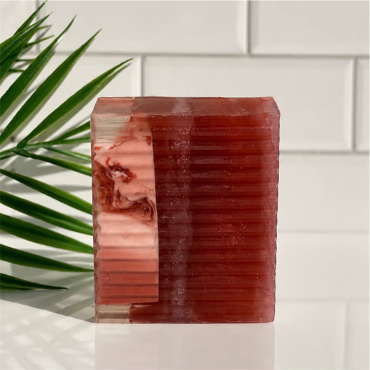 Rectangular red soap with a white background and green plant