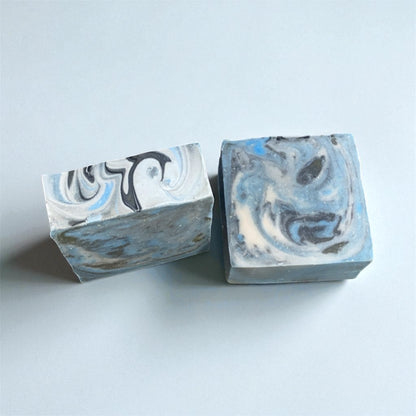 Two marbled soap bars on a light blue background