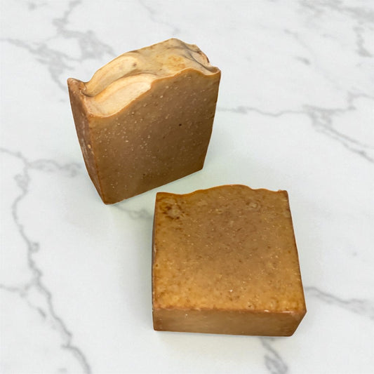 Two brown soap bars on a marble surface