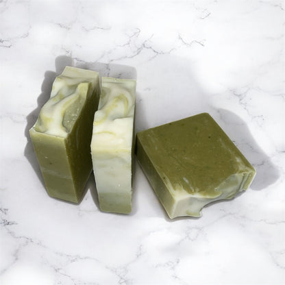Three green soap bars on a marble surface