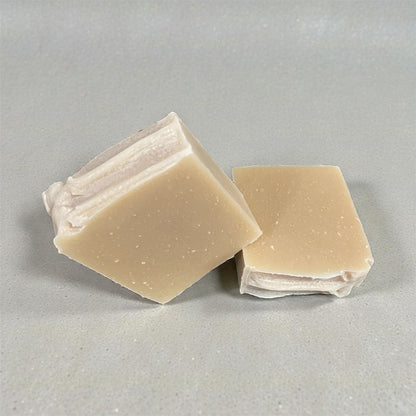 Two square bars of soap on a gray background