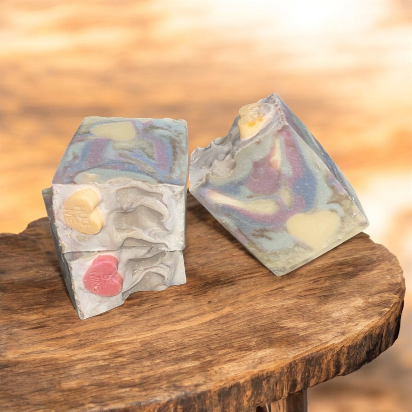 Two soap with vibrant colors sitting on a wooden bench 