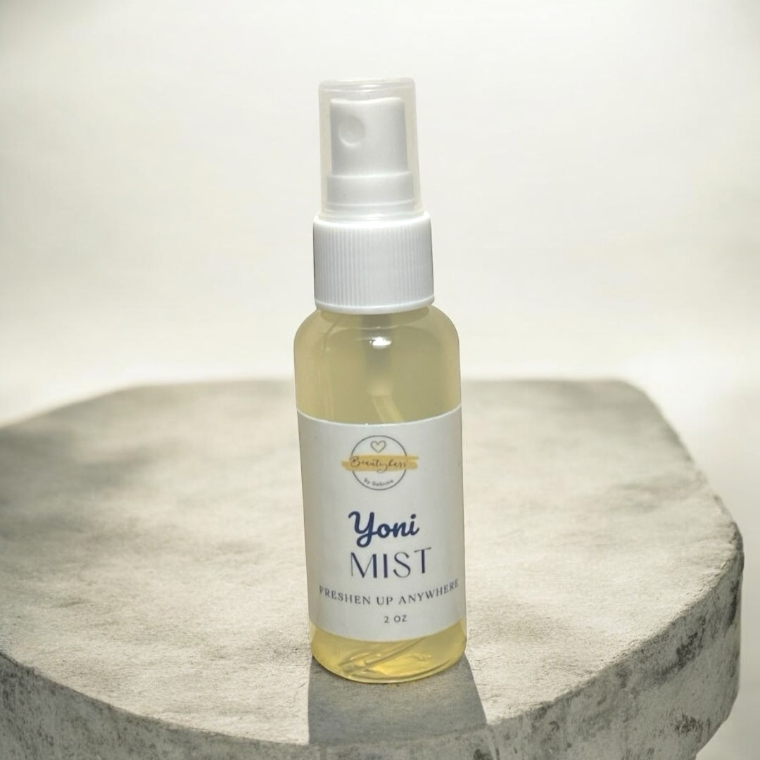 Bottle of Yoni Mist on a round stone surface with a white background