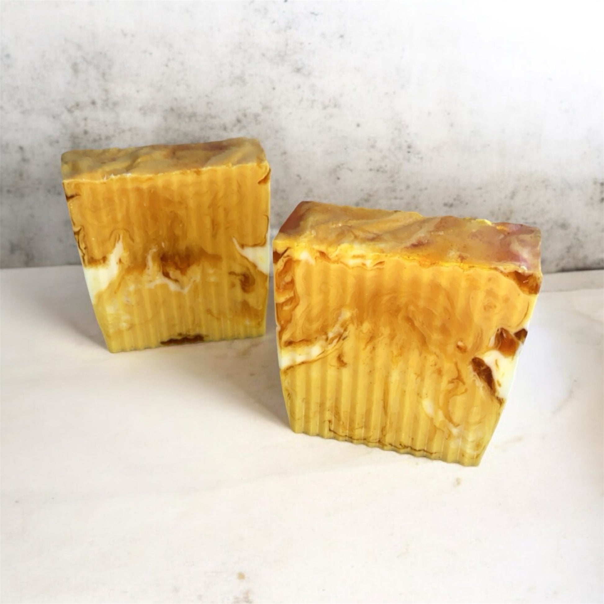 Two marbles colored turmeric soaps with white background 