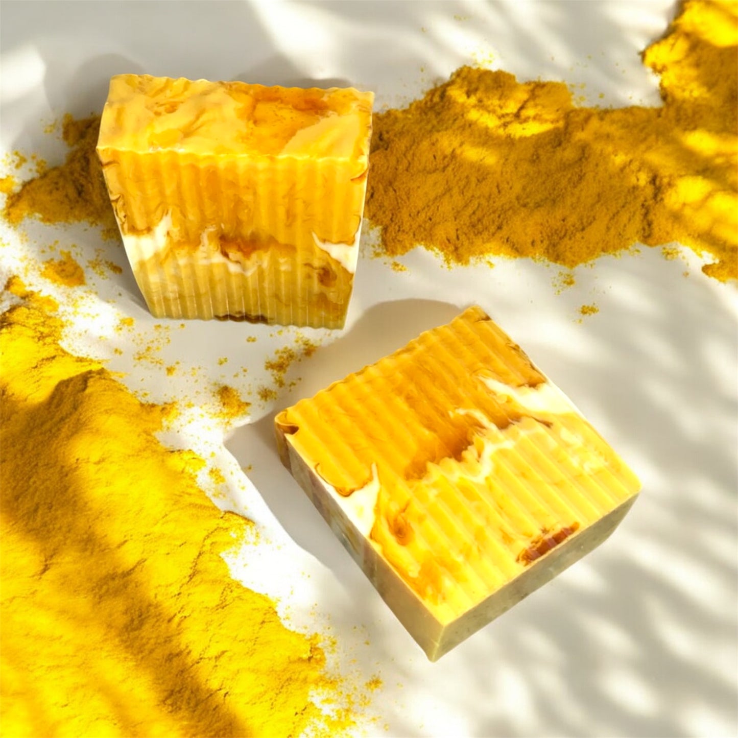 Two yellow soap bars on a white surface with scattered yellow powder.