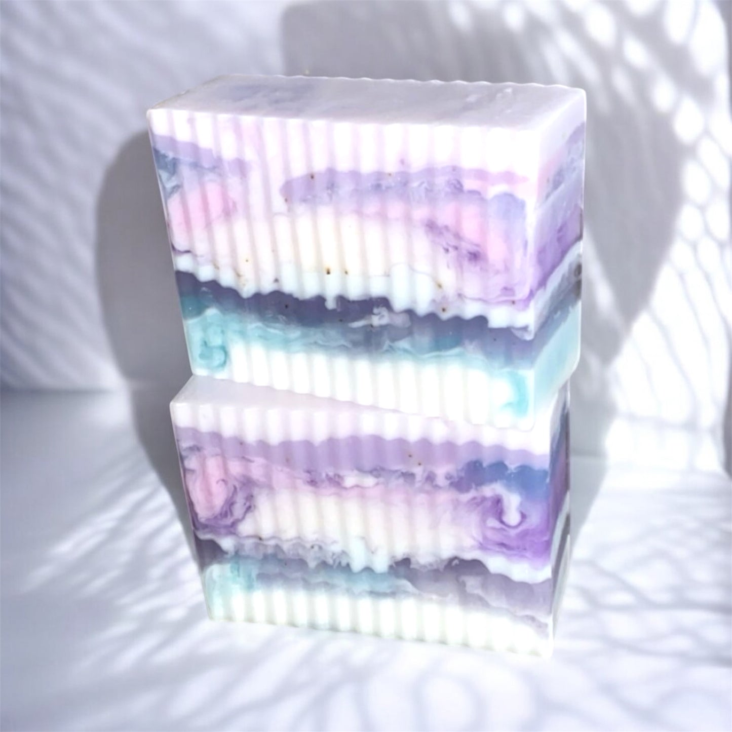 Stack of colorful soap bars with a gradient effect on a white background