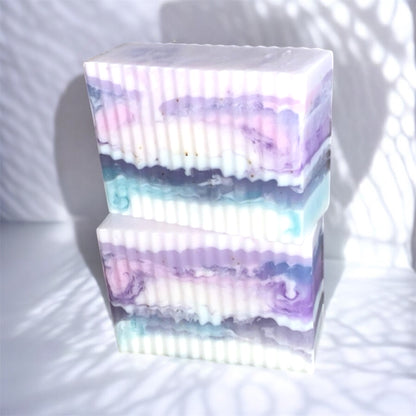 Stack of colorful soap bars with a gradient effect on a white background
