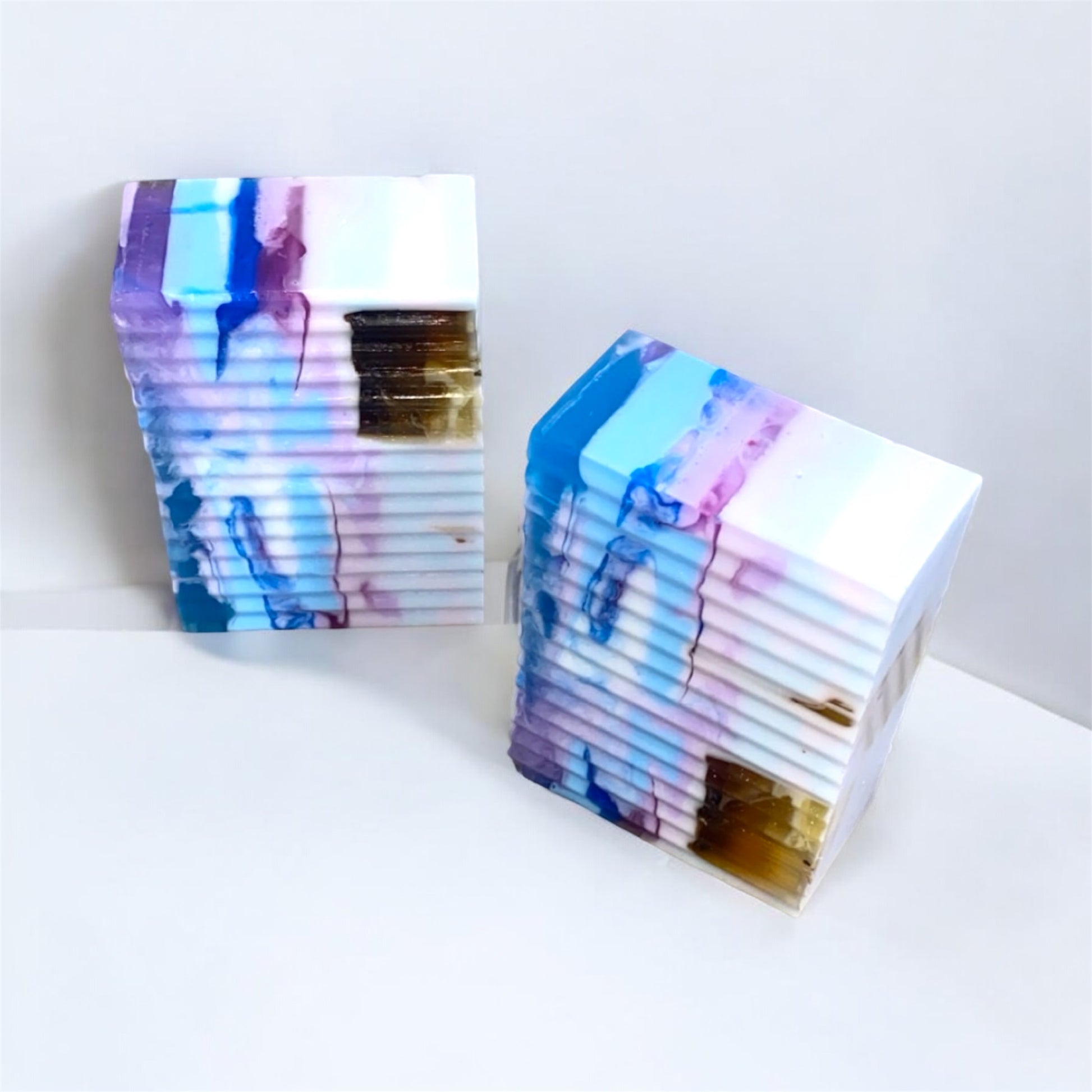 Two colorful, marbled soap bars on a white background