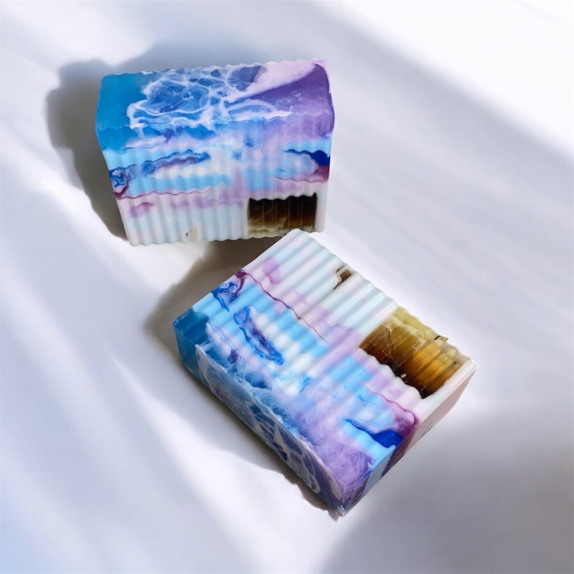 Two bars of soap with a marbled design on a white background