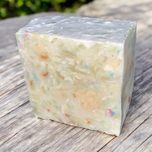 Block of soap with colorful specks on a wooden surface