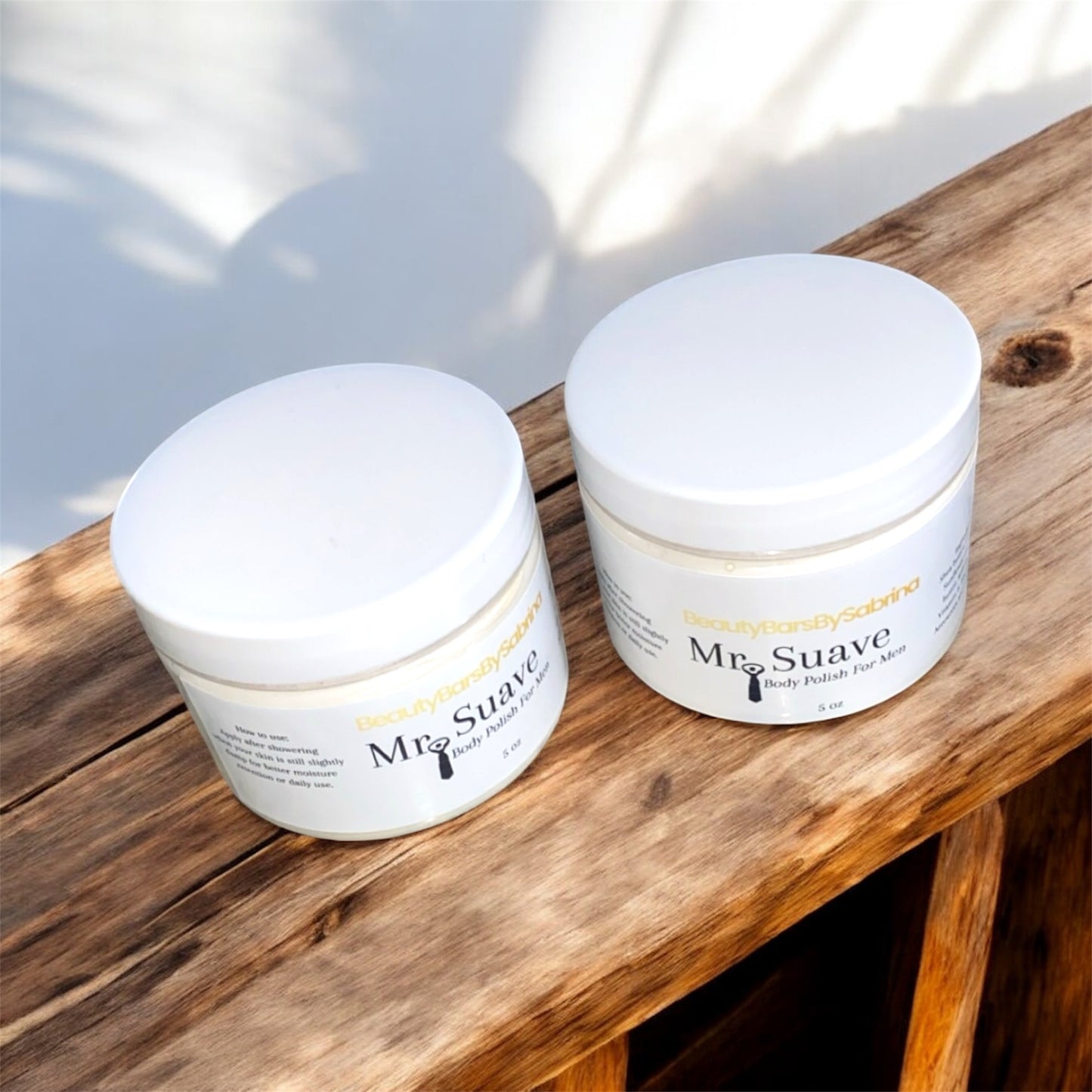 Two jars of Mr. Suave body polish on a wooden surface with a light background