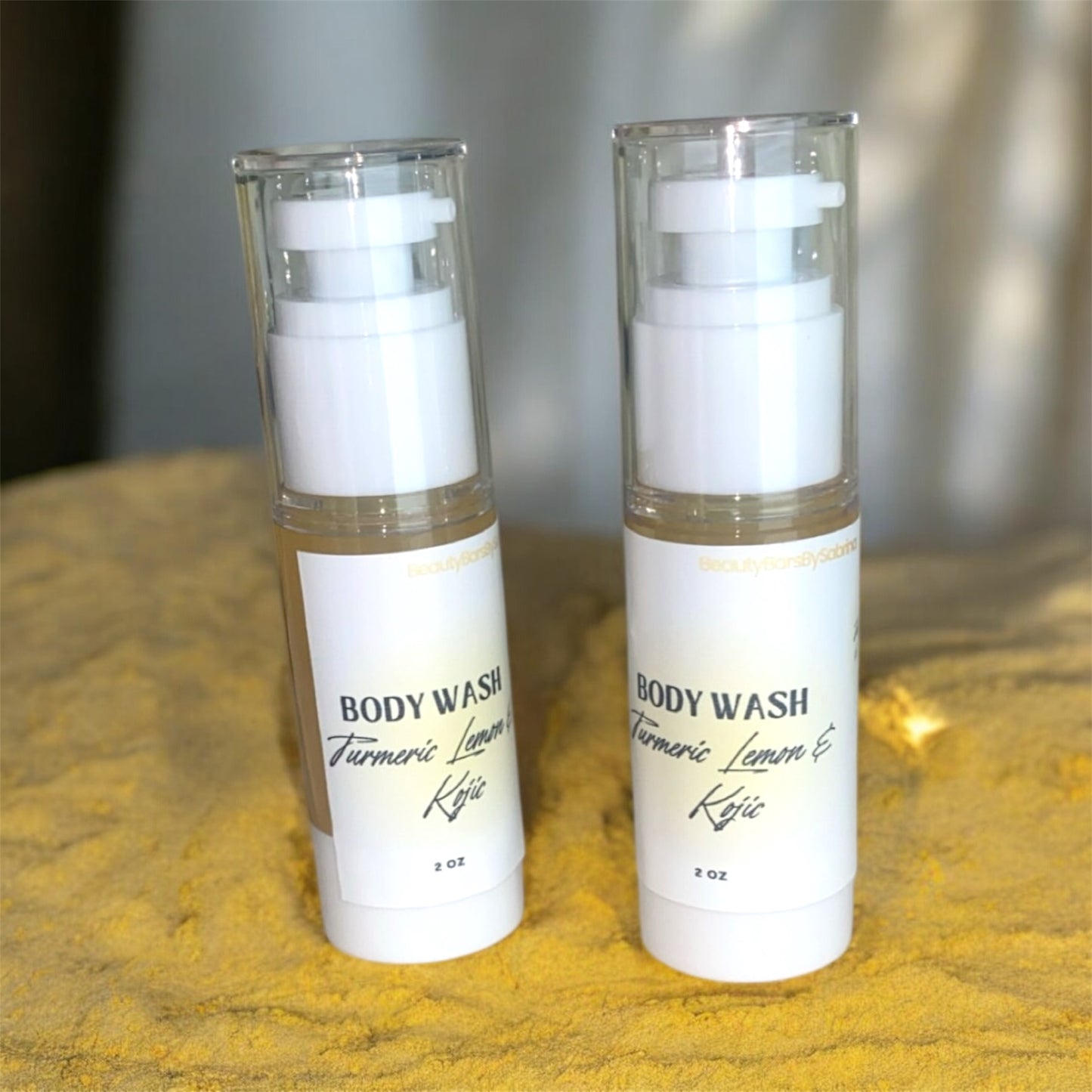 Two bottles of body wash with visible labels on a textured surface.