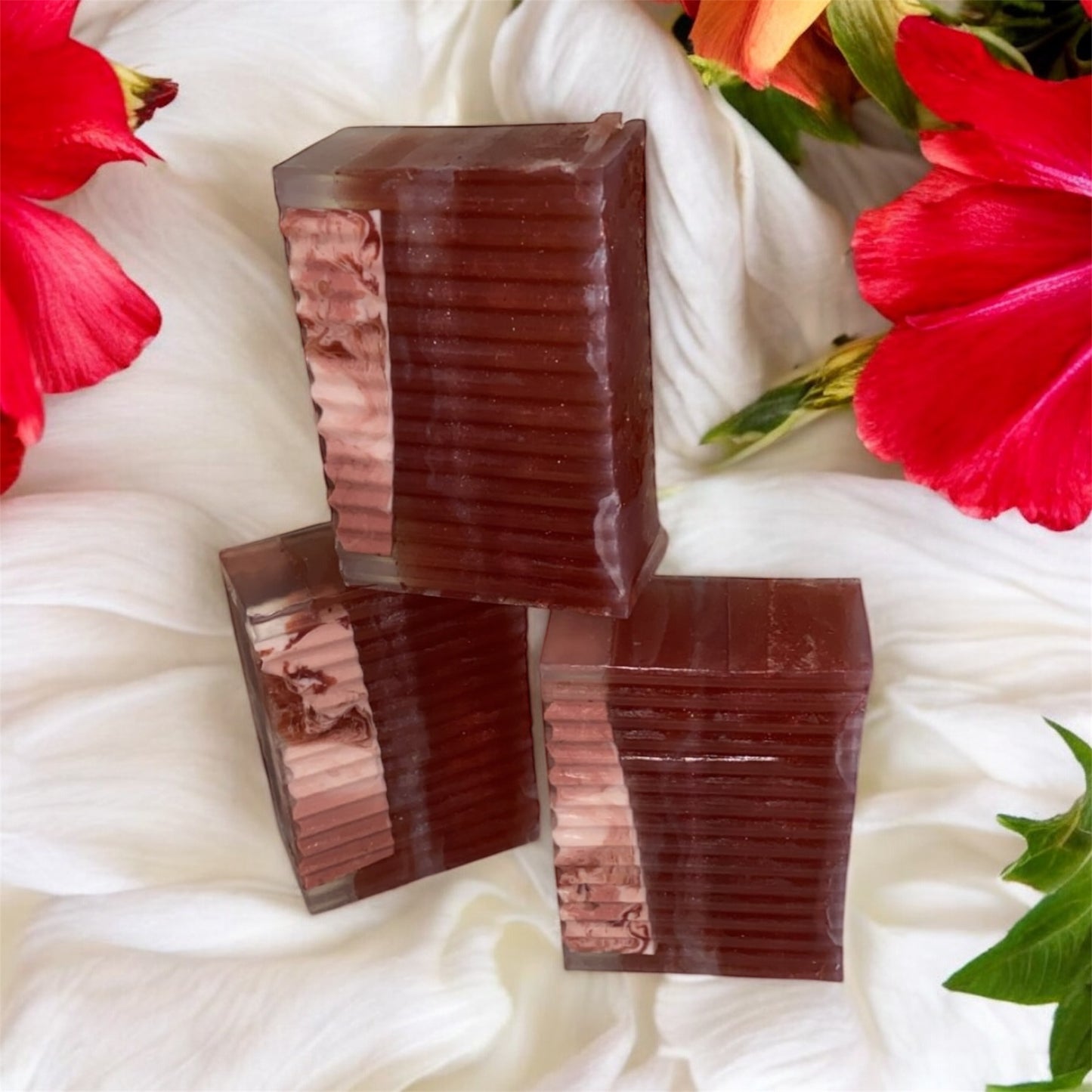 Three stacked brown rectangular bars on a white fabric background with red flowers and green leaves.