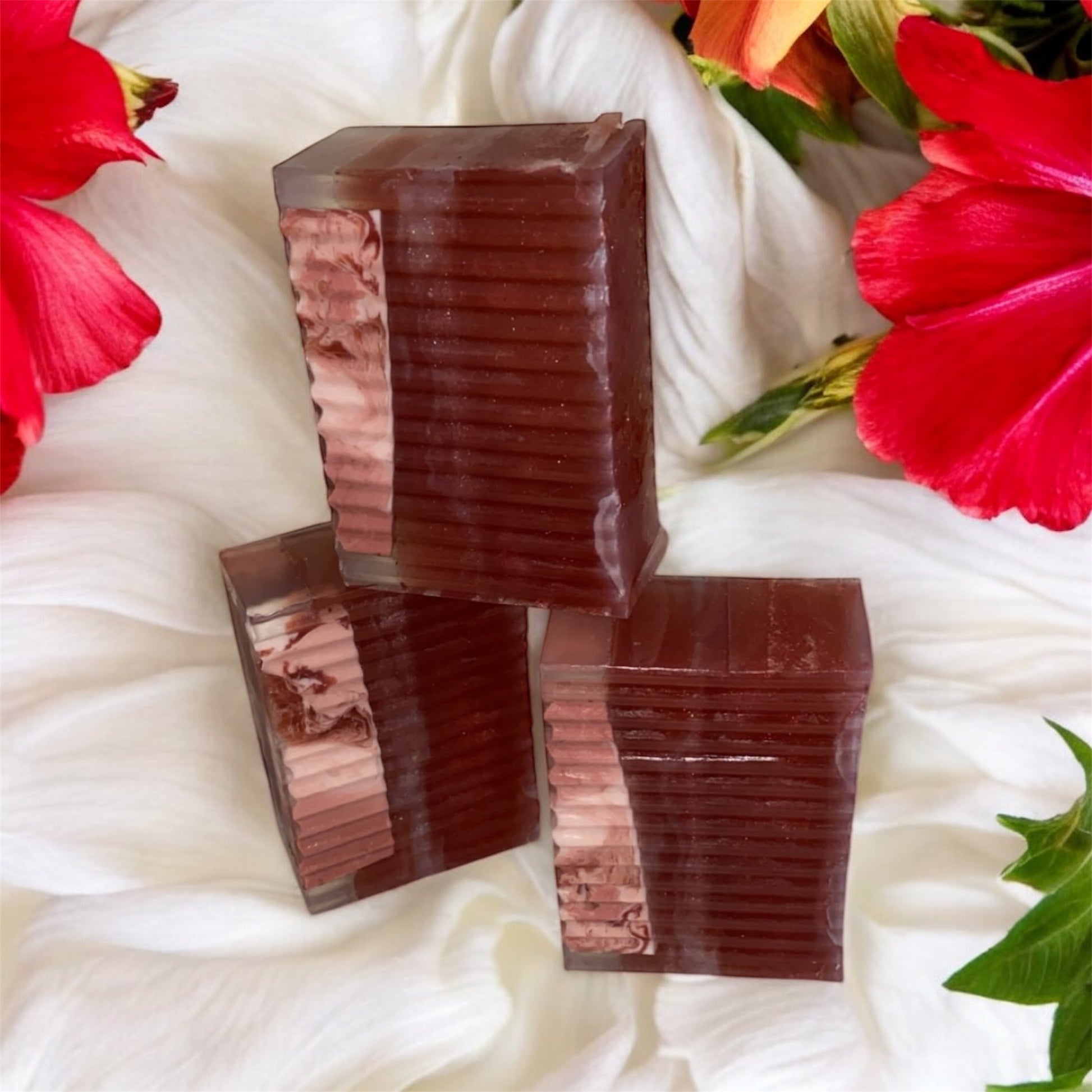 Three stacked brown rectangular bars on a white fabric background with red flowers and green leaves.