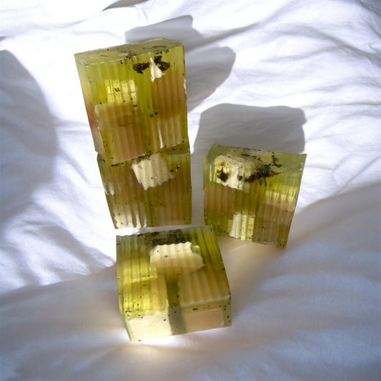 4 soap blocks with embedded objects on a white fabric background