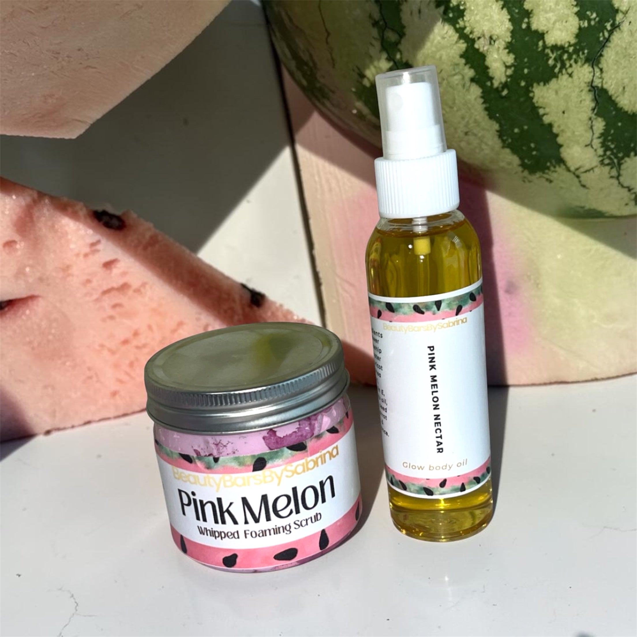 Pink Melon skincare products including a jar and a spray bottle on a surface with watermelon slices in the background.