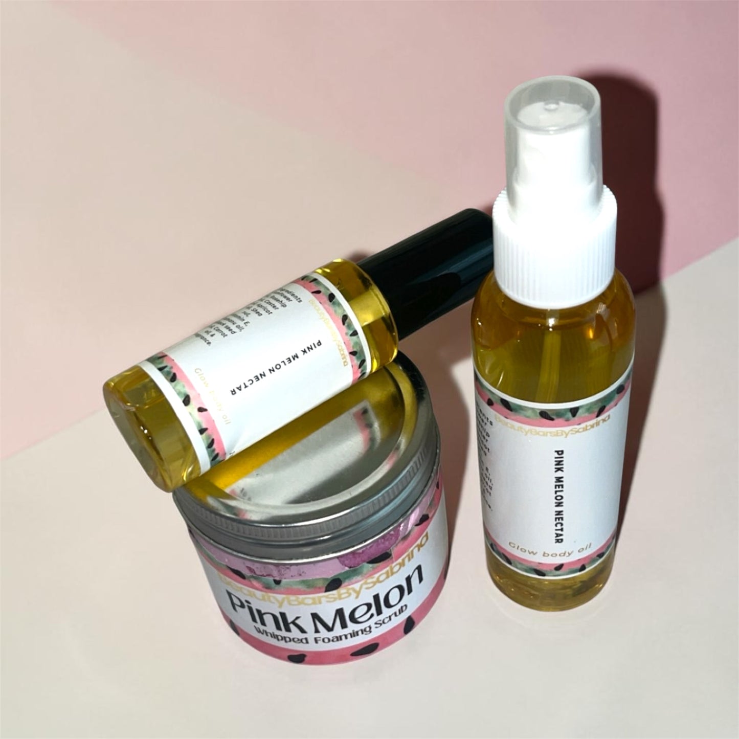 Two skincare products, a jar and a spray bottle, with 'Pink Melon' label on a light pink background.
