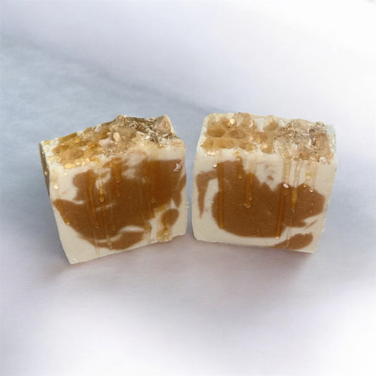 Two pieces of brown and beige soap on a white background