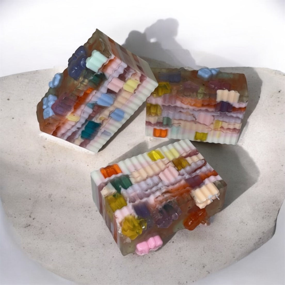 Colorful layered soap bars on a textured surface