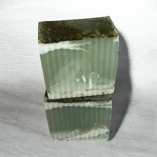 Green and white striped soap bar on a light gray background