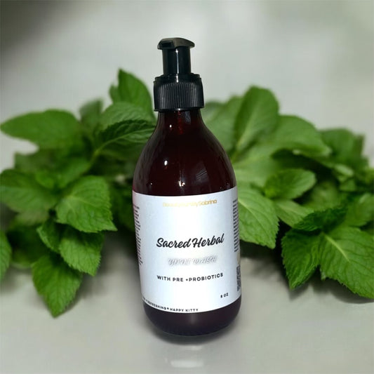 Bottle of 'Sacred Herbal' product with green leaves in the background