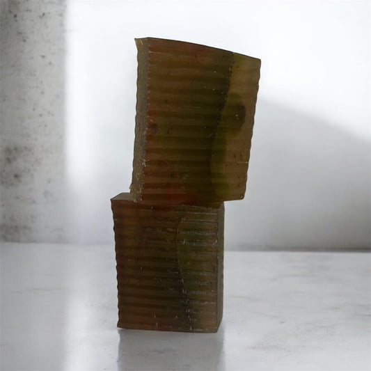 Stack of brown soap bars on a white surface with a neutral background