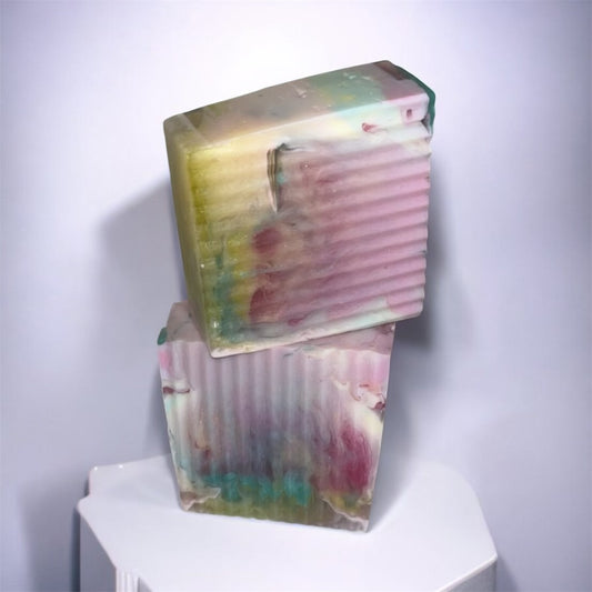 Stack of colorful soap bars on a white surface with a light gray background