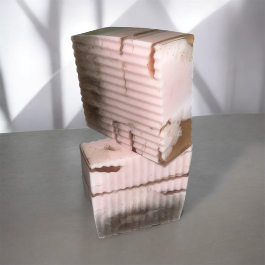 2 pink and brown soap stacked with layered design on a gray surface