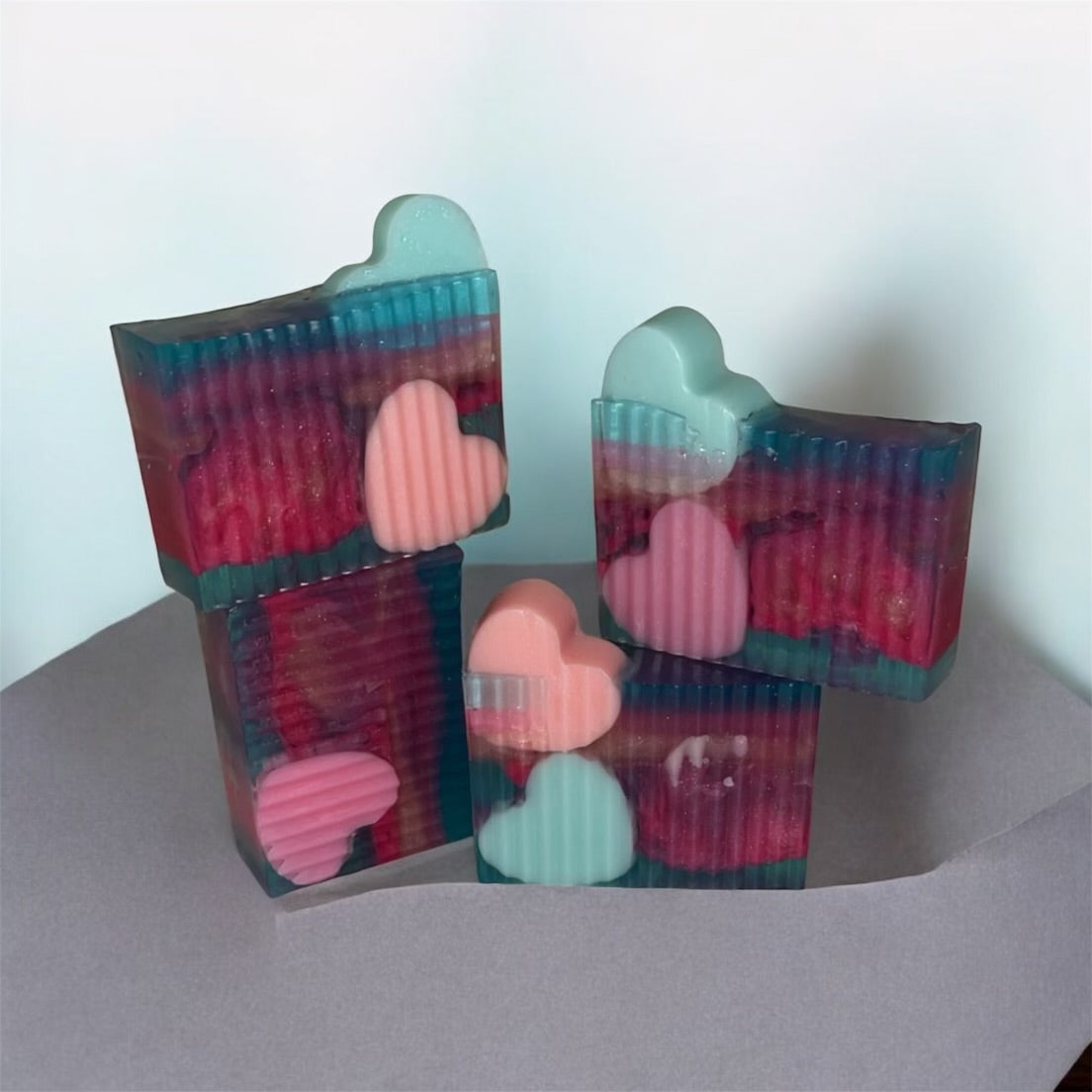 Stack of 4 heart embed soaps on white grey background 
