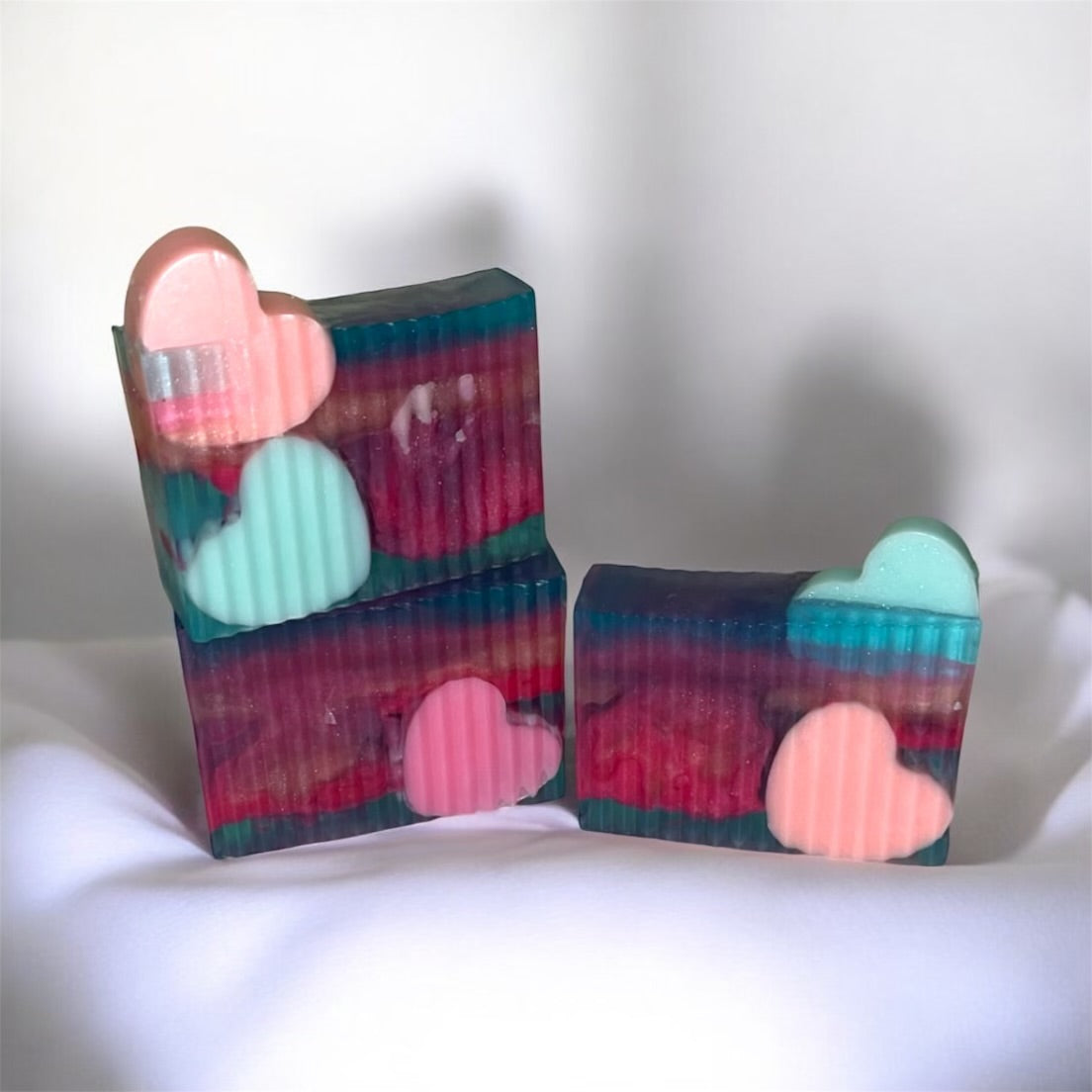 Colorful soap bars with heart shapes on a white background