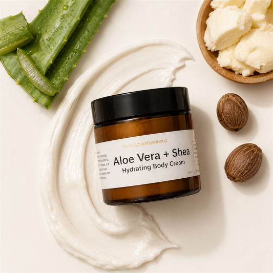 Aloe Vera + Shea hydrating body cream jar with aloe vera leaves, shea butter, and shea nuts on a white background.